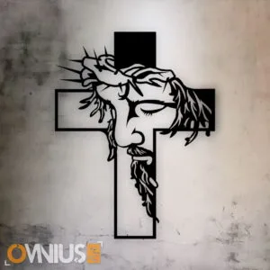 Drveni križ s licem Isusa u crnoj boji, obješen na zidu.